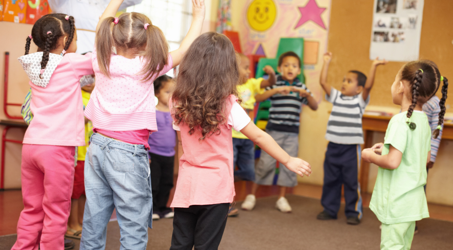 Preschool students jumping and dancing around having fun